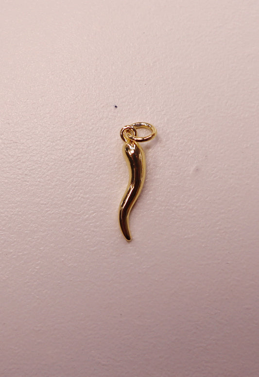Gold Italian horn-shaped pendant on a light pink background