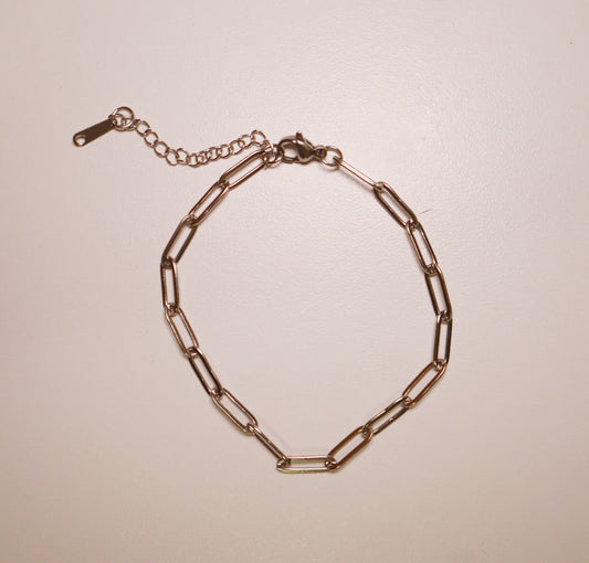 silver paperclip bracelet chain bracelet on a beige background