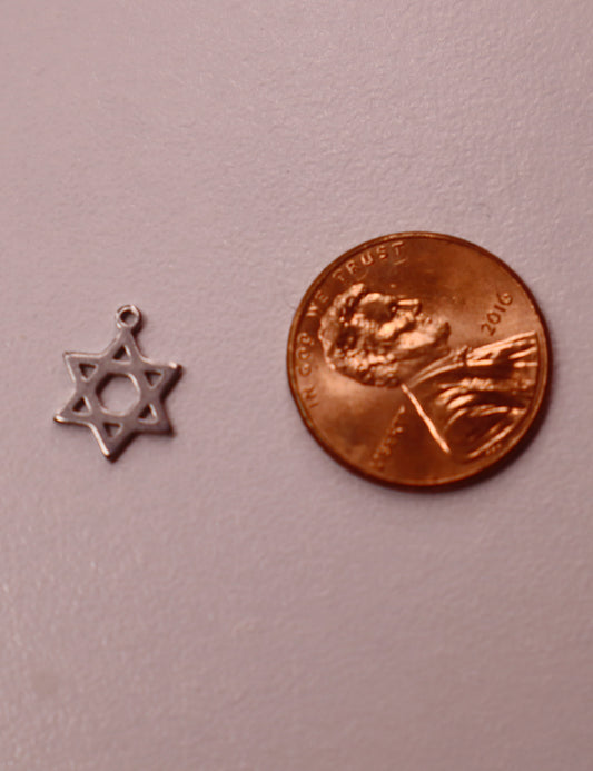 Silver Star of David charm next to a copper penny on a light pink background