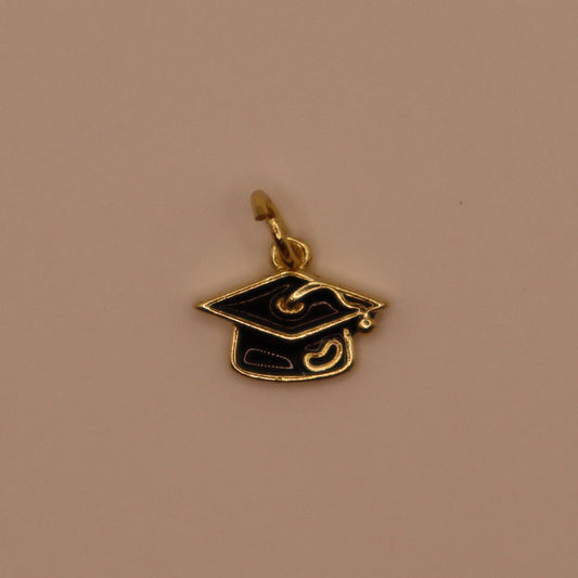 Gold and black graduation cap pendant on a beige background
