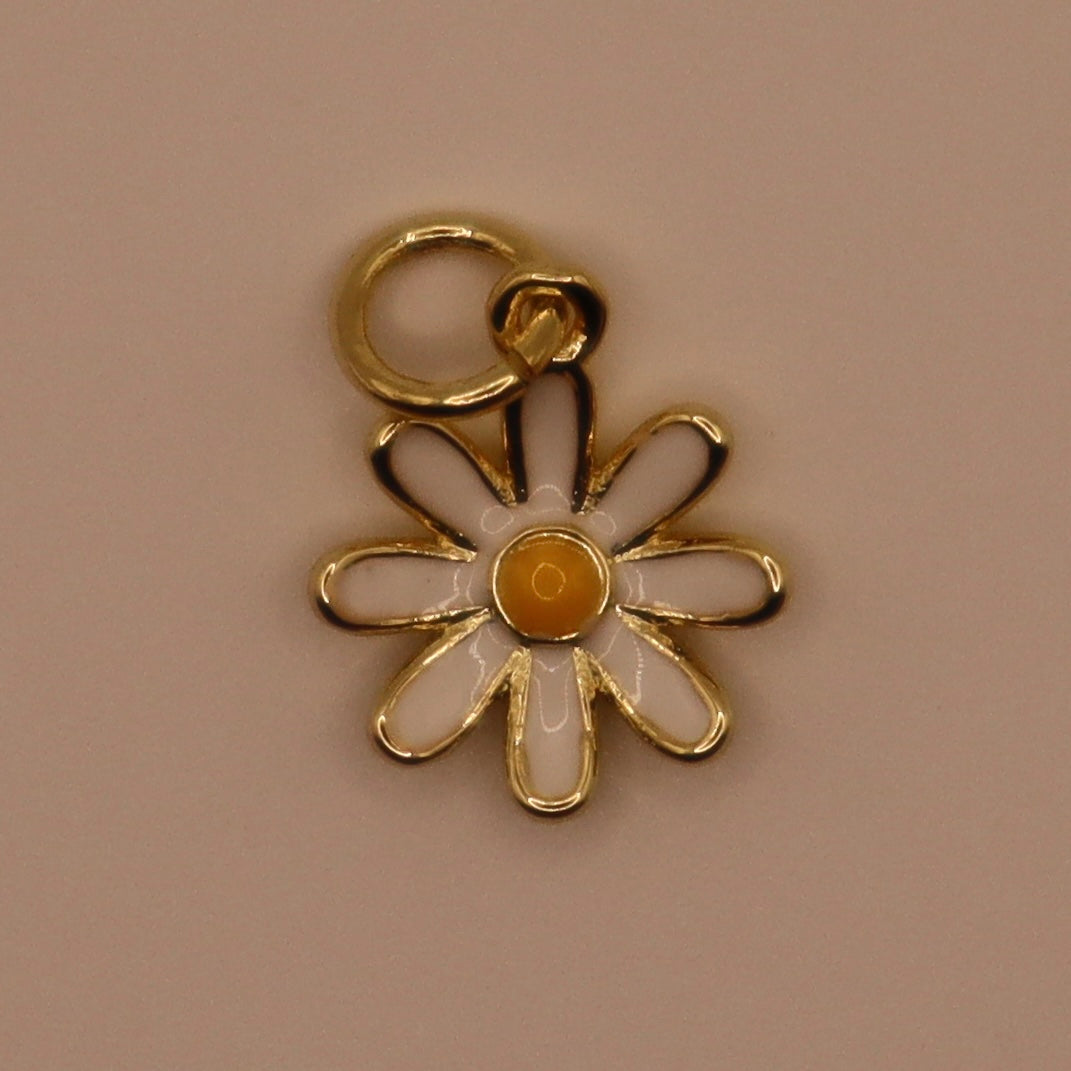 Gold flower-shaped pendant on a beige background