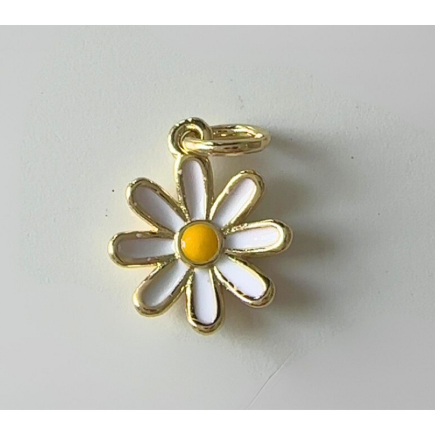 Daisy-shaped pendant with gold outline on a white background
