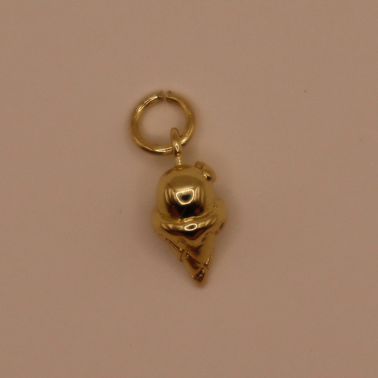 Gold ice cream charm on a beige background