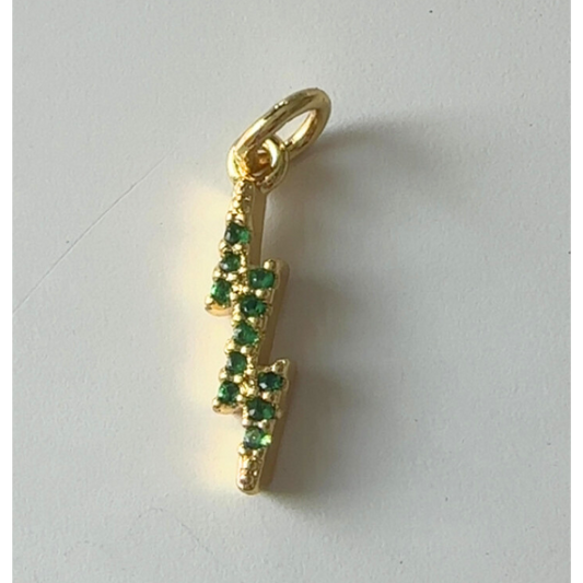 Gold pendant with green gemstones on a white background