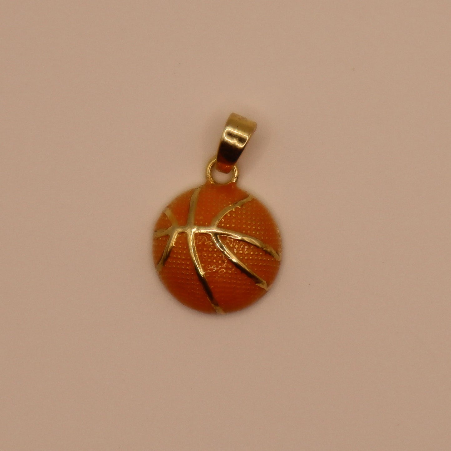 Basketball-shaped pendant with gold outline on a beige background