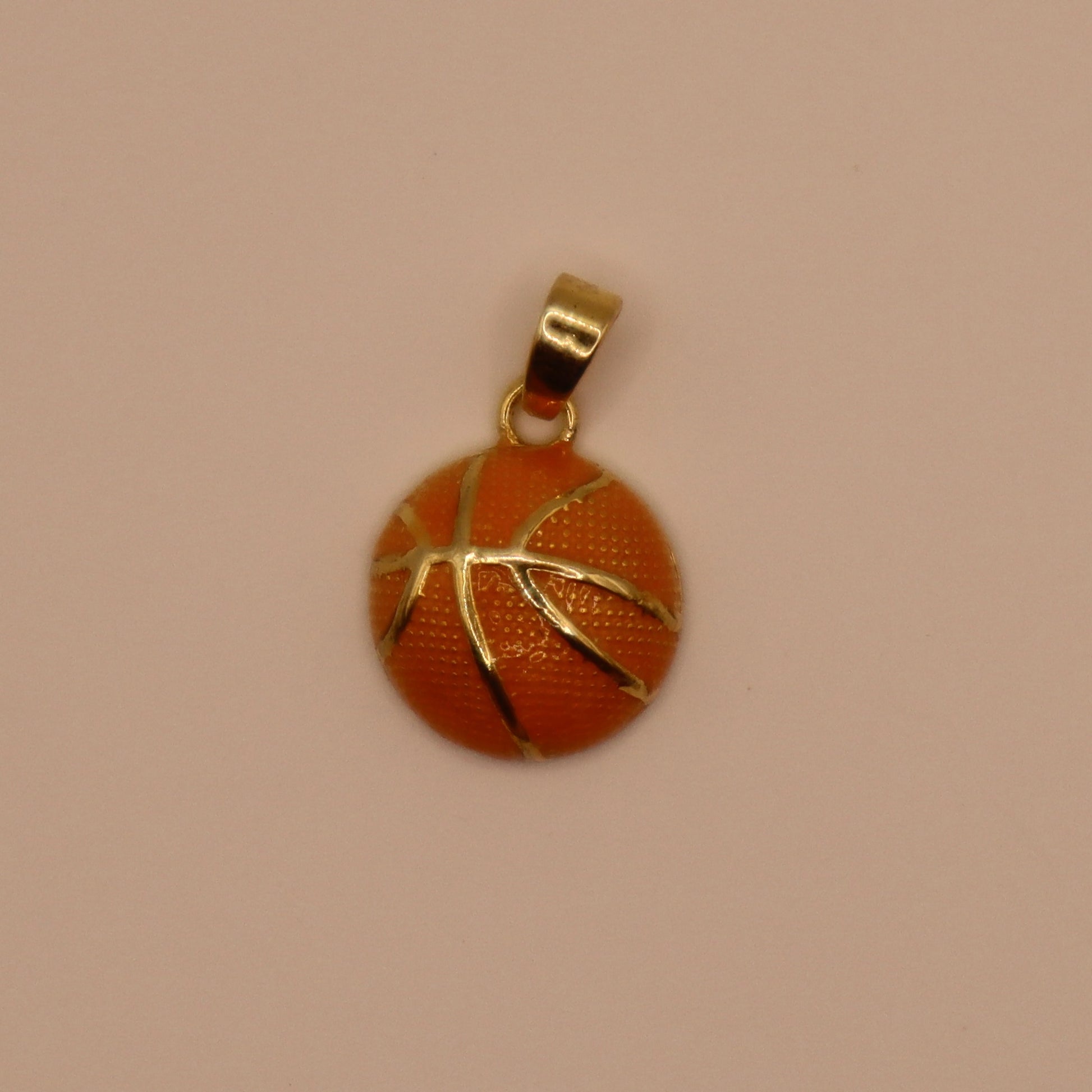 Basketball-shaped pendant with gold outline on a beige background