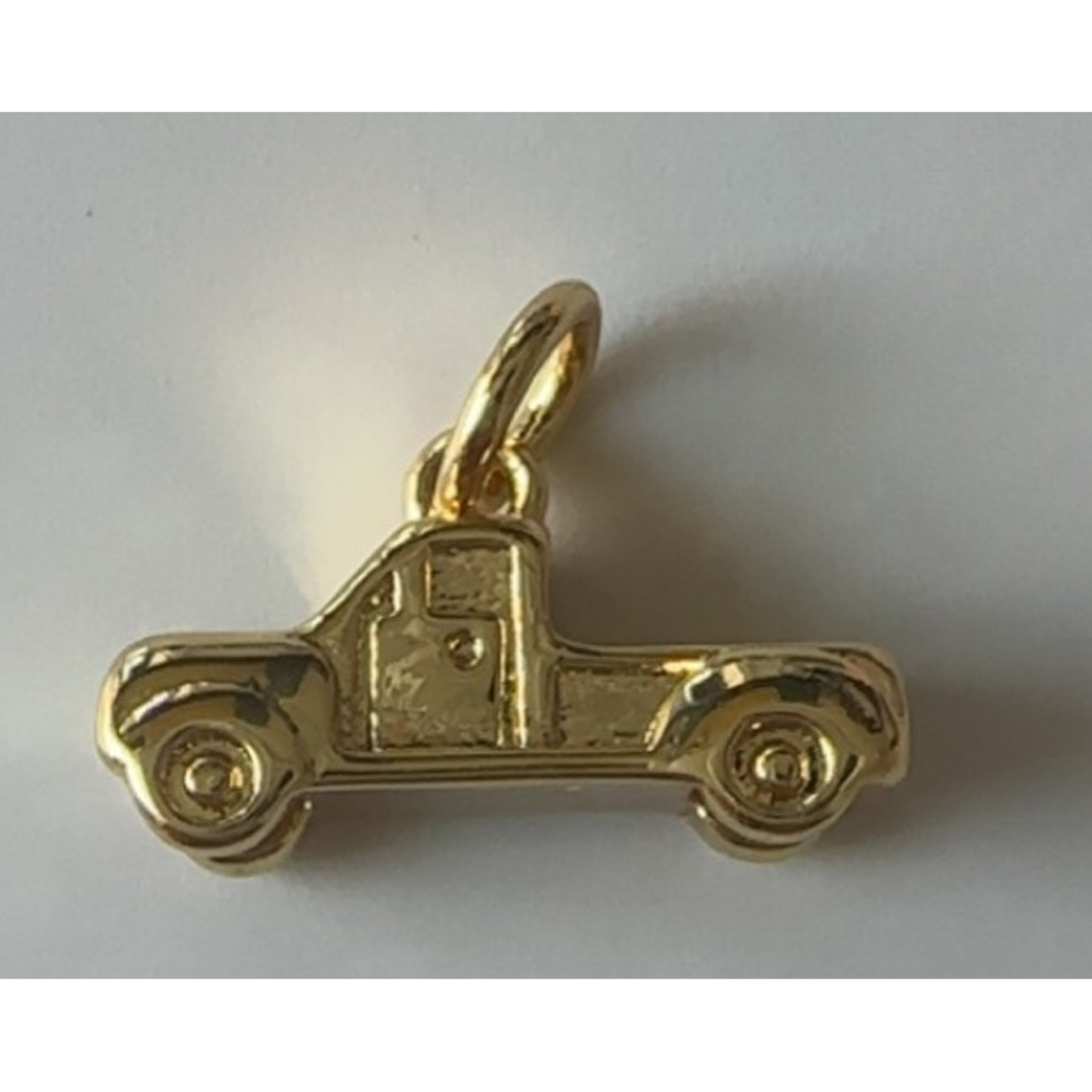 Gold truck-shaped pendant on a white background