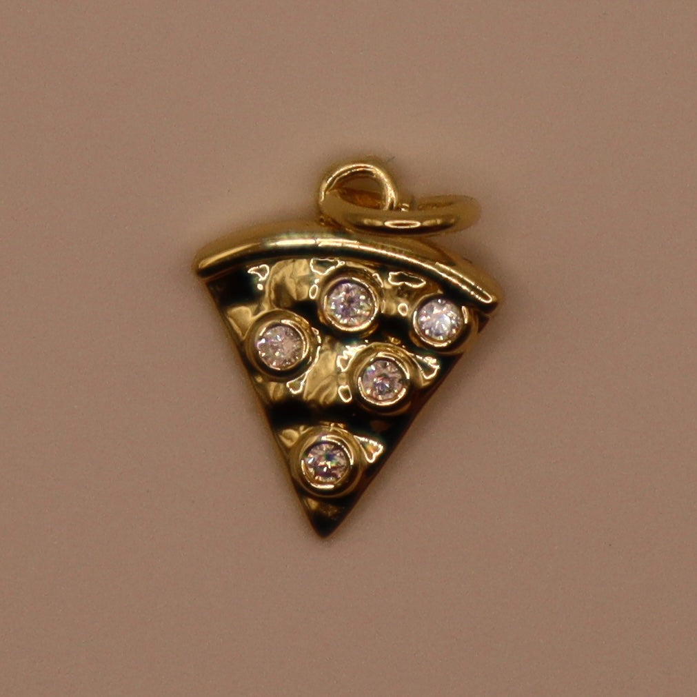 Gold pizza slice pendant with embedded stones on a beige background
