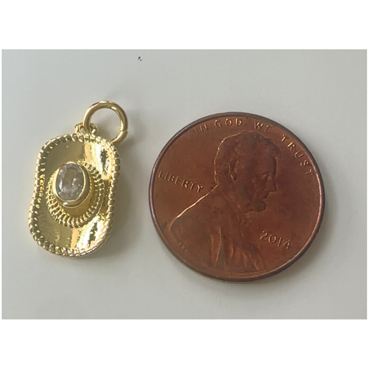 gold cowgirl hat charm next to penny