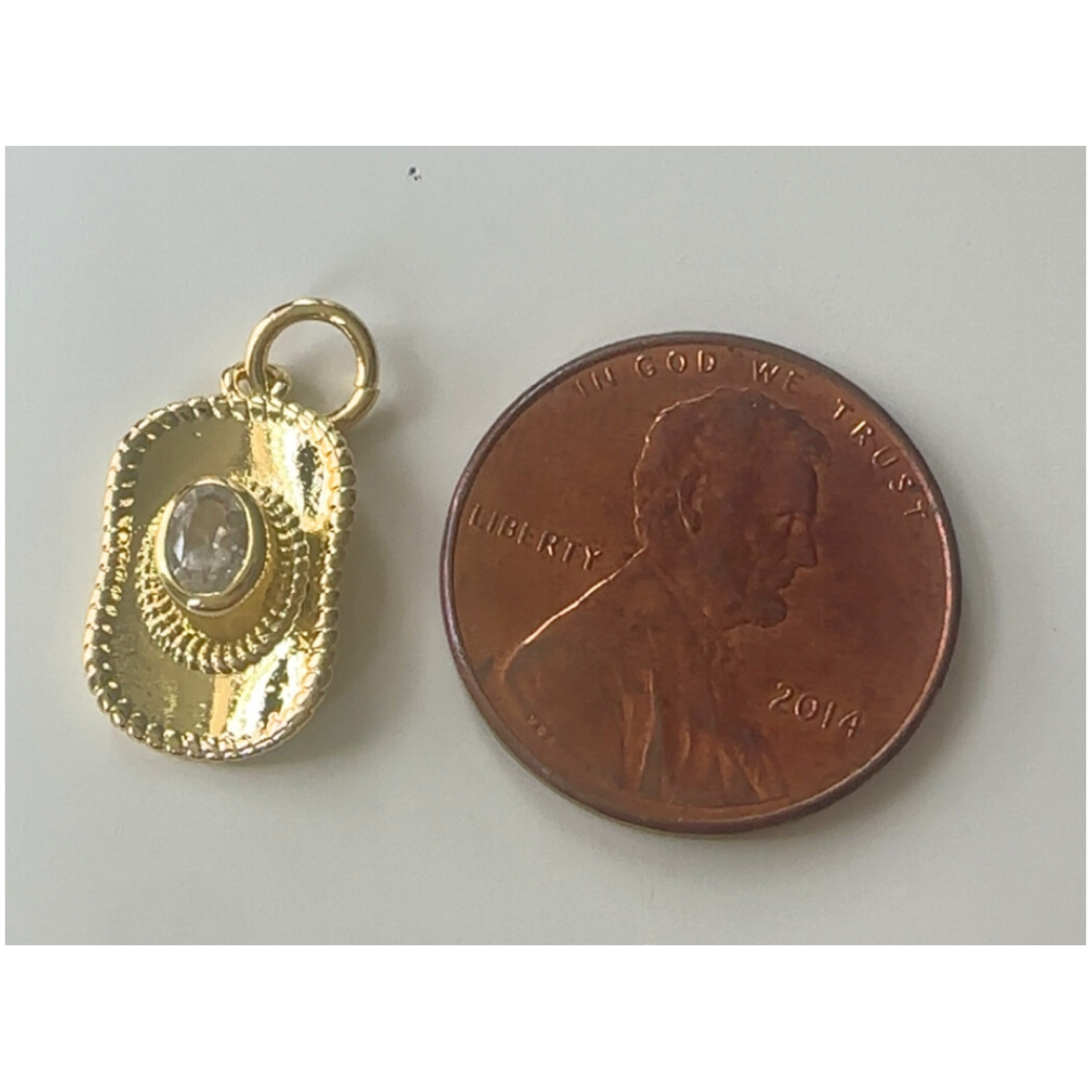 gold cowgirl hat charm next to penny
