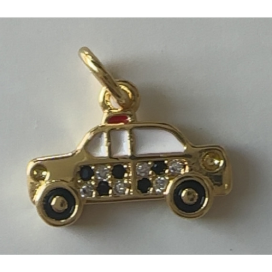 Gold taxi-shaped pendant with gemstones on a white background