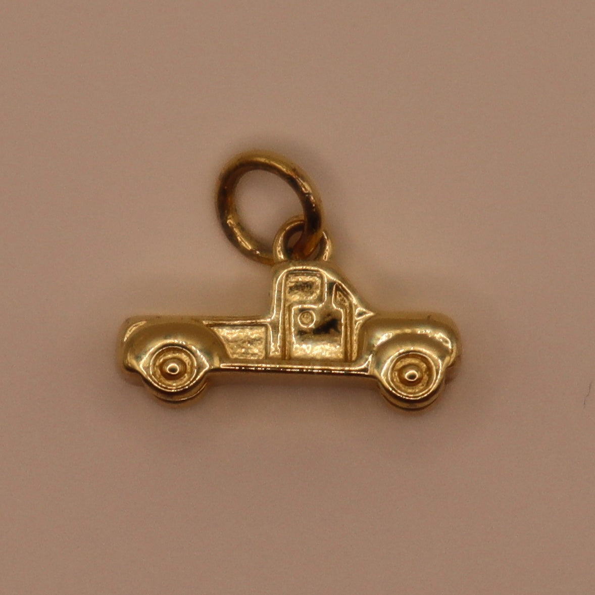 Gold truck charm on a beige background
