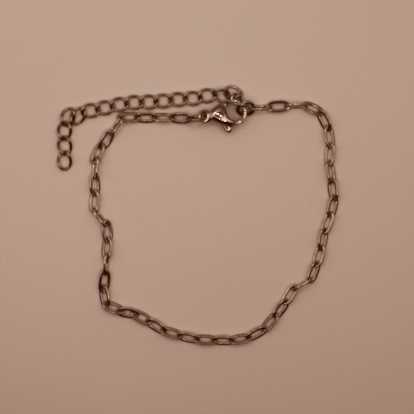 Silver dainty bracelet on a beige background