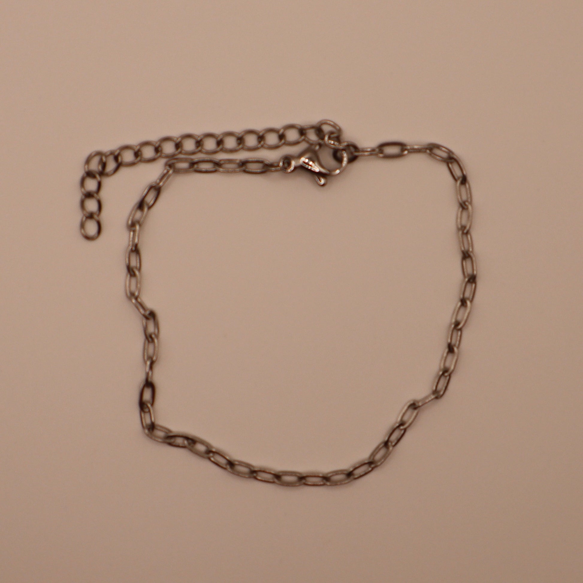 Silver dainty bracelet on a beige background