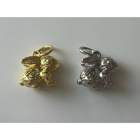 Gold and silver rabbit-shaped charms on a white background