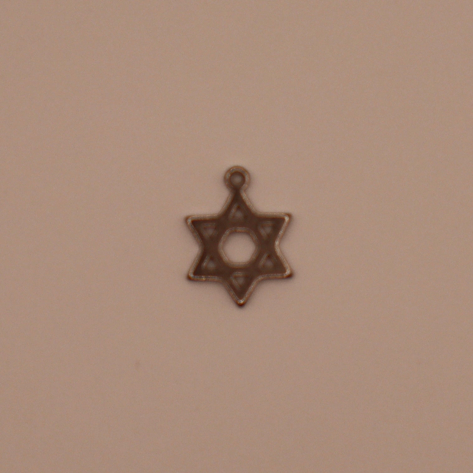 Star of David charm on a beige background